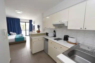 a kitchen with a sink and a bed in a room at Finikoudes Sunrise Sea View Lux in Larnaka