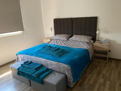 a bedroom with a large bed with a blue blanket at Gorgeous 1 Bedroom apartment close to Town Centre in Limassol