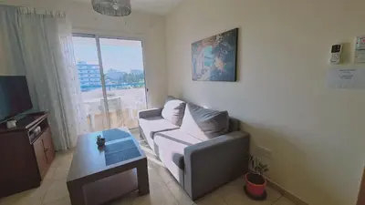 a living room with a couch and a table at STAY Suncity Apartment in Larnaka