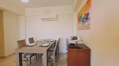 a room with a table with chairs and a telephone at STAY Suncity Apartment in Larnaka