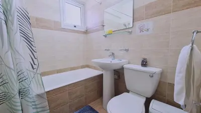 a bathroom with a toilet and a sink and a bath tub at STAY Suncity Apartment in Larnaka