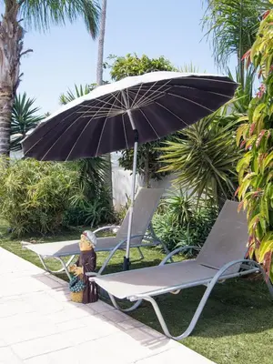 two lounge chairs and an umbrella on the grass at Maestro Villa in Meneou