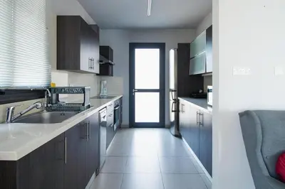 a kitchen with a sink and a door to a window at Maestro Villa in Meneou
