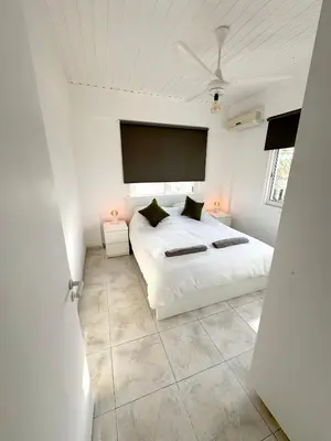 a white bedroom with a bed and a large window at Casa Sea Breeze in Larnaka