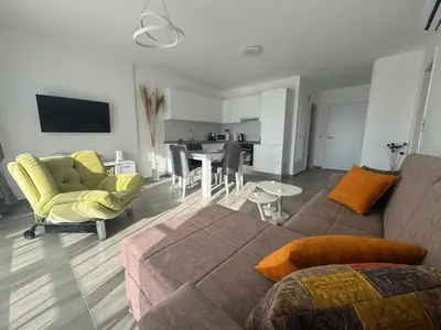 a living room with a couch and chairs and a table at Cozy apartment at Thalassa Beach Resort, Northern Cyprus in Paralimni