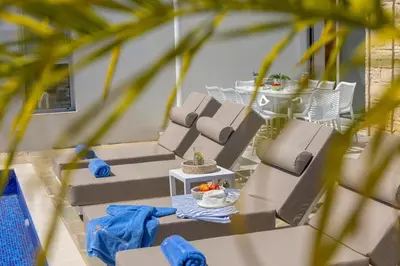 a patio with lounge chairs and a table with fruit at Villa Milos 36 in Protaras