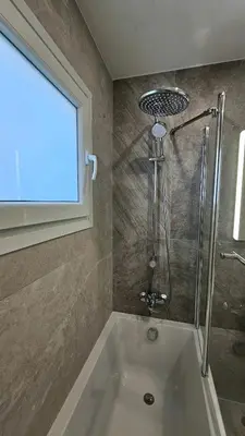 a bath tub in a bathroom with a shower at Kanika 3 bedroom city beach in Limassol