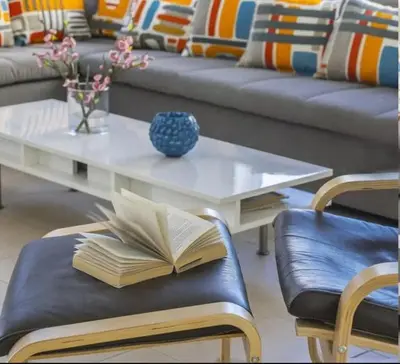 a living room with a coffee table with a book on it at Sandy Feet Beach House in Paralimni