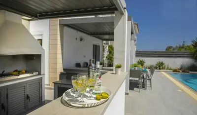 a kitchen with a table with wine glasses on it at Sandy Feet Beach House in Paralimni