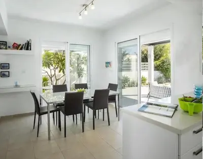 a kitchen and dining room with a table and chairs at Sandy Feet Beach House in Paralimni