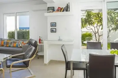 a living room with a table and chairs and a couch at Sandy Feet Beach House in Paralimni