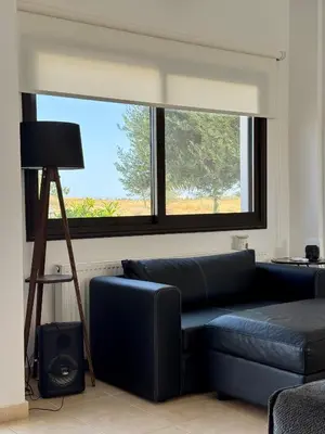 a living room with a blue couch and a window at Lazuli Zen Villa with Private Pool in Pyla
