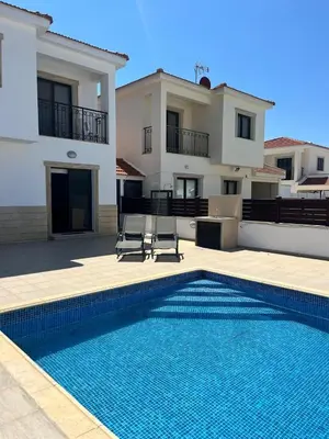 a villa with a swimming pool in front of a house at Lazuli Zen Villa with Private Pool in Pyla