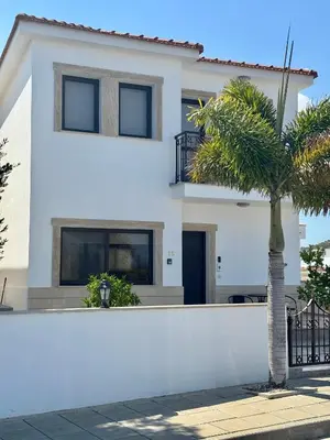 a white house with a palm tree in front of it at Lazuli Zen Villa with Private Pool in Pyla