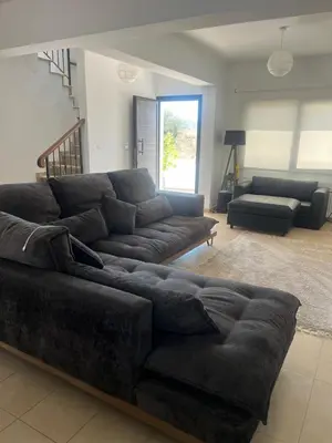 a living room with a large black couch in a room at Lazuli Zen Villa with Private Pool in Pyla