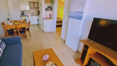 a living room with a blue couch and a kitchen at STAY Camelia Apartment in Larnaka
