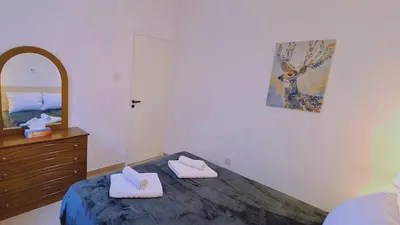 a bedroom with a bed and a dresser and a mirror at STAY Camelia Apartment in Larnaka