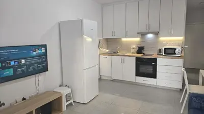 a kitchen with white cabinets and a white refrigerator at STAY Historia Apartment in Nicosia