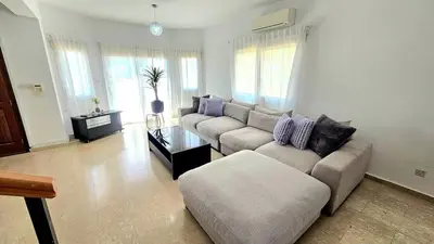 a living room with a couch and a table at Suburban Family Villa in Limassol