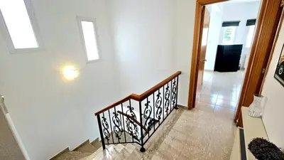 a staircase in a home with white walls and windows at Suburban Family Villa in Limassol