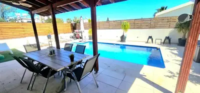 a table and chairs next to a swimming pool at Suburban Family Villa in Limassol