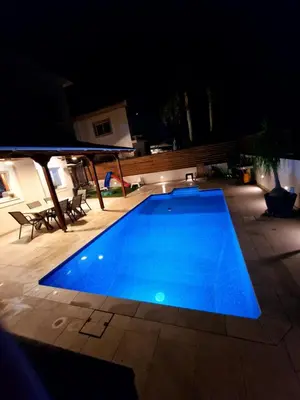 a large blue swimming pool at night at Suburban Family Villa in Limassol