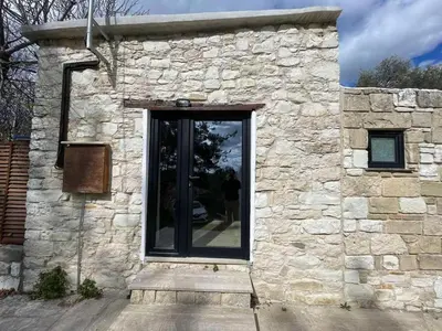 a door of a stone building with a window at The Hideaway in Arminou