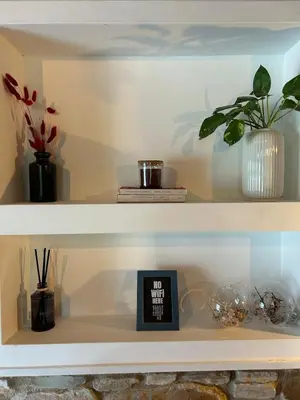 a shelf with plants and a clock on it at The Hideaway in Arminou