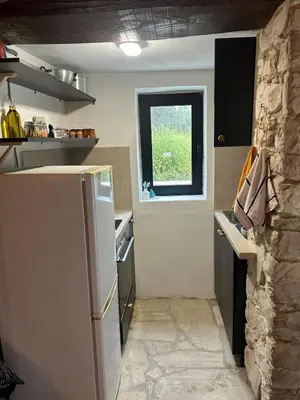 a kitchen with a refrigerator and a window at The Hideaway in Arminou