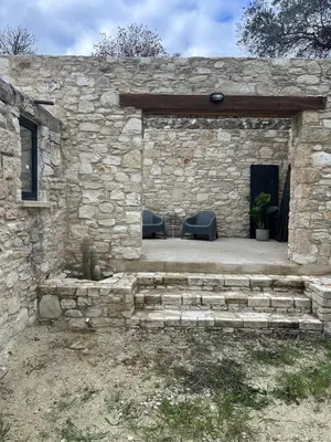 a stone building with two chairs in front of it at The Hideaway in Arminou