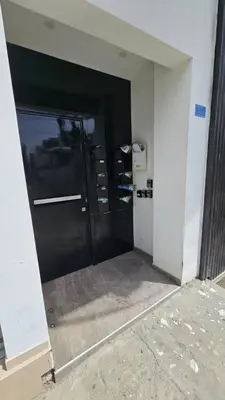 a hallway with a black door in a building at The Cozy Seaside Retreat in Larnaka