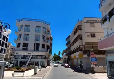 a city street with buildings and cars on the road at The Cozy Seaside Retreat in Larnaka