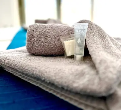 a pile of towels and a bottle of sunscreen on a bed at Central Napa Escape - Adults Only in Ayia Napa