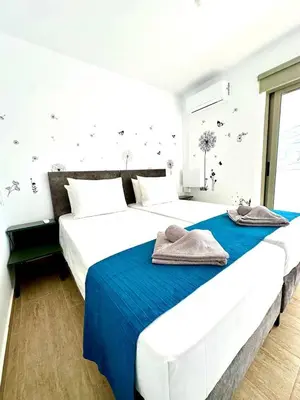 two white beds in a bedroom with blue sheets at Central Napa Escape - Adults Only in Ayia Napa