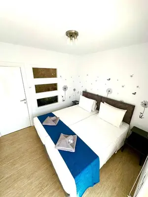 a bedroom with a large white bed with a blue blanket at Central Napa Escape - Adults Only in Ayia Napa