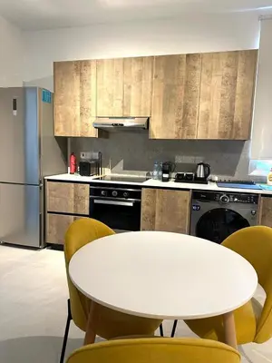 a kitchen with a white table and yellow chairs at Verasia Acute Stay in Engomi in Engomi