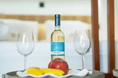 a bottle of wine and two glasses on a table at SuiteNapa22 in Ayia Napa