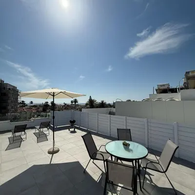 a patio with a table and chairs and an umbrella at Luxurious Penthouse in Larnaca Center 300m From The Beach in Larnaka