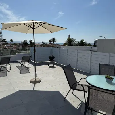 a patio with an umbrella and a table and chairs at Luxurious Penthouse in Larnaca Center 300m From The Beach in Larnaka