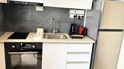 a kitchen with a sink and a refrigerator at City Centre 2-Bedroom, Old Town, Nicosia in Nicosia