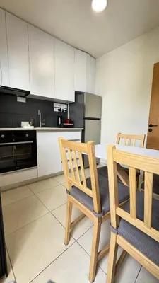 a kitchen with a table and two wooden chairs at City Centre 2-Bedroom, Old Town, Nicosia in Nicosia