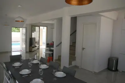 a dining room with a table with plates and wine glasses at Mimosa 18 Beachhouse Villa in Protaras