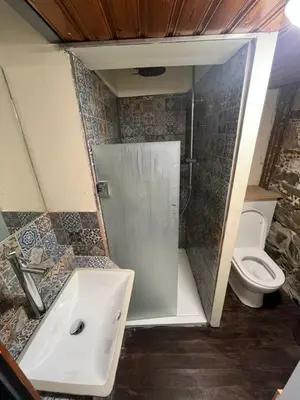 a bathroom with a shower and a sink and a toilet at Odou Off-grid in Odhou