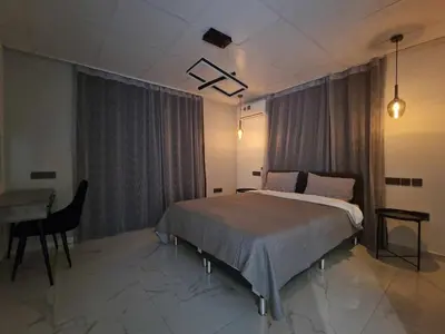 a bedroom with a bed and a table and a desk at Modern House in Touristic Pyla - Oroklini! in Larnaka