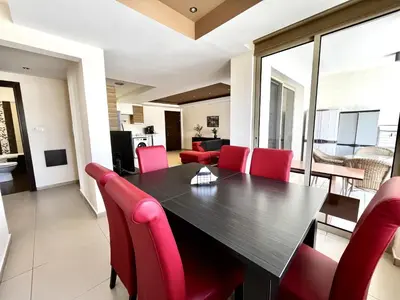 a dining room with a table and red chairs at STAY Mesa Luxe Apartment in Limassol