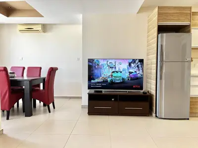 a living room with a television and a table with red chairs at STAY Mesa Luxe Apartment in Limassol