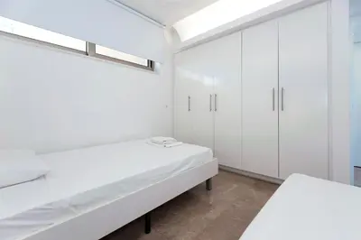 a white room with white cabinets and a bed at Apartment Marina - Beachfront in Protaras