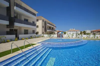 a swimming pool in front of a building at Cozy 2-Bedroom Beach Flat in Paralimni
