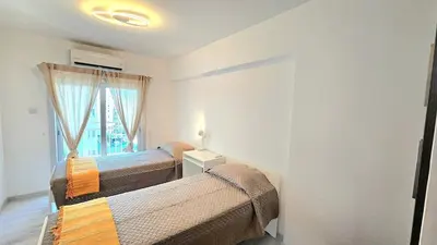 a bedroom with two beds and a window at Molos city centre living in Limassol