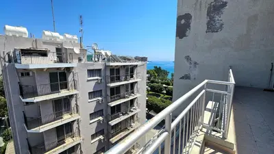 an apartment building with a balcony and the ocean at Molos city centre living in Limassol